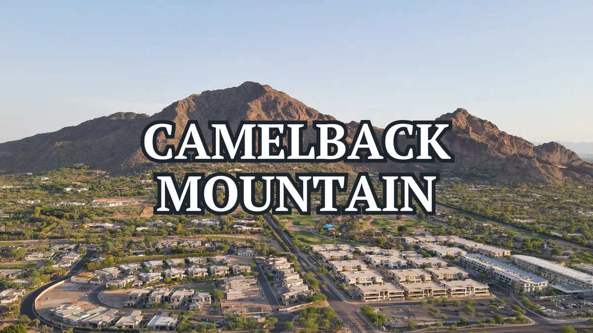 A wide, panoramic view of Camelback Mountain and the surrounding neighborhoods under a clear sky. The tranquil landscape suggests opportunities for hiking, outdoor exploration, and community activities in the Scottsdale area.
