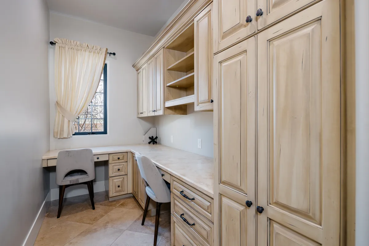 A serene indoor workspace with a dedicated desk, comfortable chair, window, and ample storage. The setting suggests productivity and quiet reflection, ideal for remote work or creative pursuits.